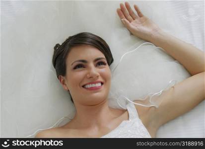 High angle view of a bride lying on the bed and smiling