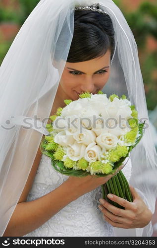 High angle view of a bride smelling a bouquet of flowers