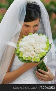 High angle view of a bride smelling a bouquet of flowers