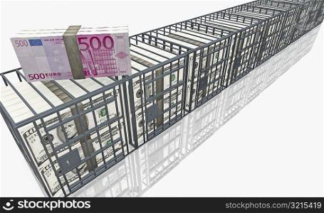 High angle view of a bundle of five hundred Euro banknote on top of a cage of American dollar bills