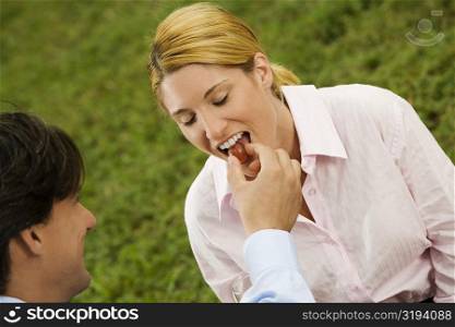 High angle view of a businessman feeding a cherry to a businesswoman