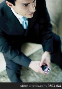 High angle view of a businessman holding a mobile phone