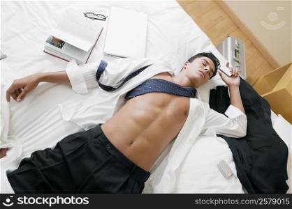 High angle view of a businessman sleeping on the bed