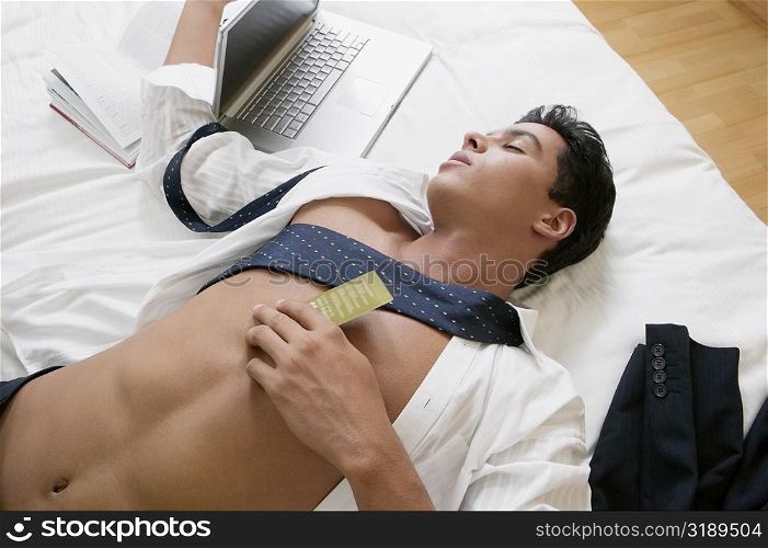 High angle view of a businessman sleeping on the bed