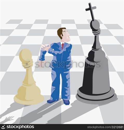 High angle view of a businessman standing on a chessboard between a pawn and a king