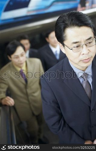 High angle view of a businessman standing on an escalator