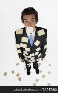 High angle view of a businessman standing with adhesive notes on his body