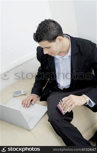 High angle view of a businessman using a laptop on a couch