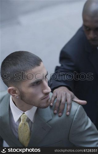 High angle view of a businessman with his hands on another businessman&acute;s shoulder