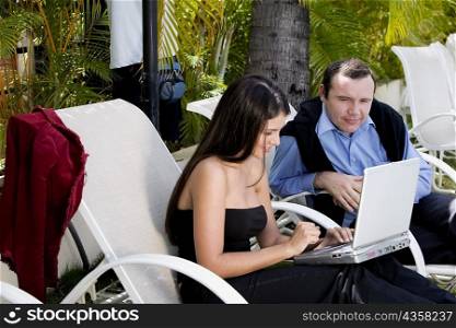High angle view of a businesswoman and a businessman working on a laptop