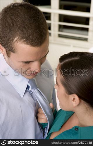 High angle view of a businesswoman holding a businessman by his tie