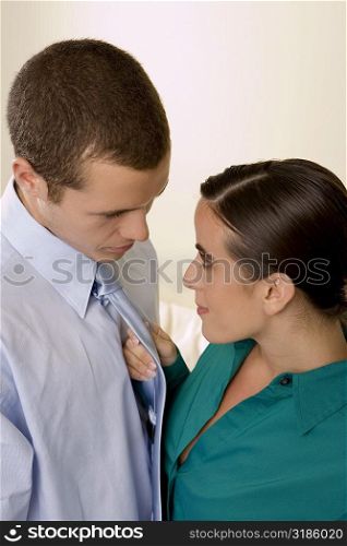 High angle view of a businesswoman holding a businessman by his tie