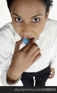 High angle view of a businesswoman holding a globe in her mouth