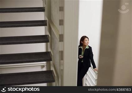 High angle view of a businesswoman holding a mobile phone and smiling