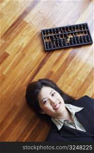 High angle view of a businesswoman lying on the hardwood floor and smiling