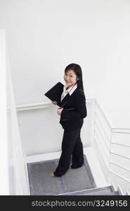 High angle view of a businesswoman standing on the staircase and smiling