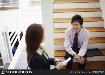 High angle view of a businesswoman talking to a businessman and smiling