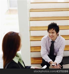 High angle view of a businesswoman talking to a businessman and smiling