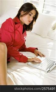 High angle view of a businesswoman using a laptop on the bed
