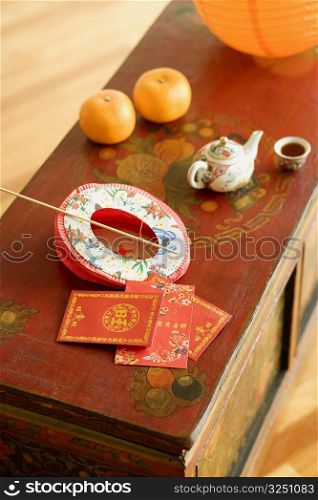 High angle view of a Chinese lantern and a kettle with envelopes on the table