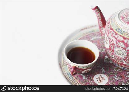 High angle view of a cup of black tea and a teapot on a tray
