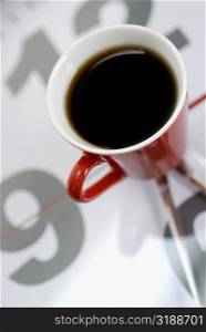 High angle view of a cup of black tea on a clock