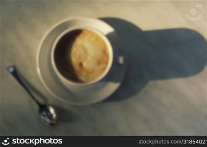 High angle view of a cup of coffee with a saucer and a spoon