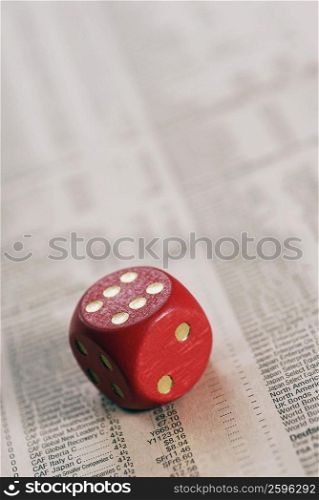 High angle view of a dice on stock market data sheet