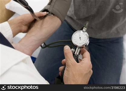High angle view of a doctor checking a patient&acute;s blood pressure