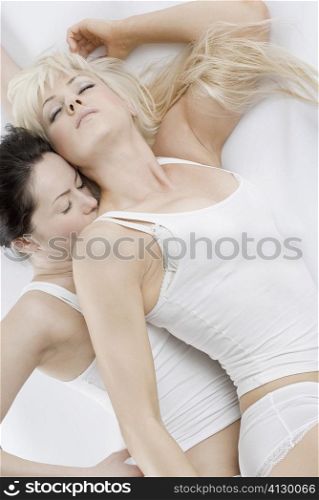High angle view of a female homosexual couple lying on the bed