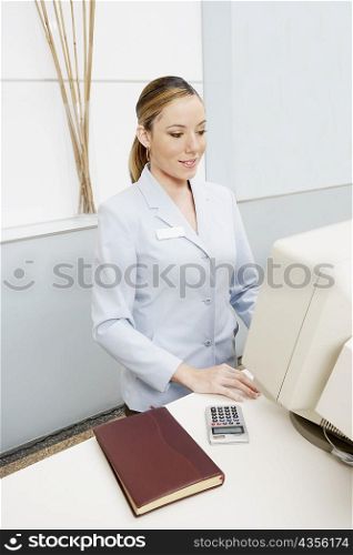 High angle view of a female receptionist using a computer