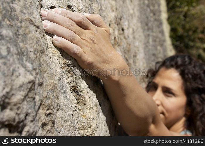 High angle view of a female rock climber scaling a rock face