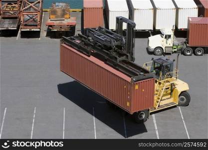 High angle view of a forklift picking up a container at a harbor