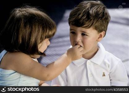 High angle view of a girl feeding her brother