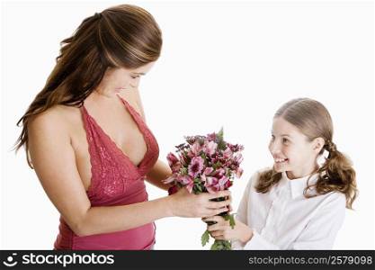 High angle view of a girl giving her mother a bunch of flowers