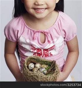 High angle view of a girl holding eggs in a bird&acute;s nest
