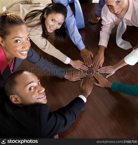 High angle view of a group of business executives with their hands on a table