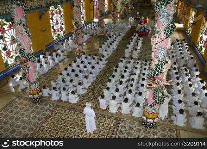 High angle view of a group of people praying in a monastery, Cao Dai Monastery, Tay Ninh, Vietnam