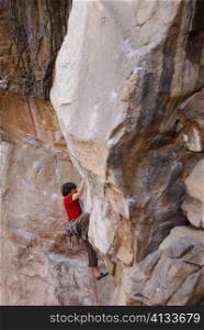 High angle view of a male rock climber scaling a rock face