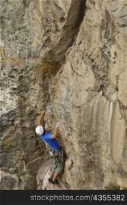 High angle view of a male rock climber scaling a rock face