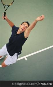 High angle view of a man serving at a tennis match