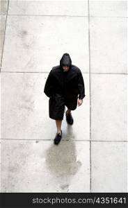High angle view of a man walking in a raincoat