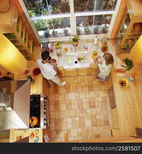 High angle view of a mature couple cutting vegetables in the kitchen