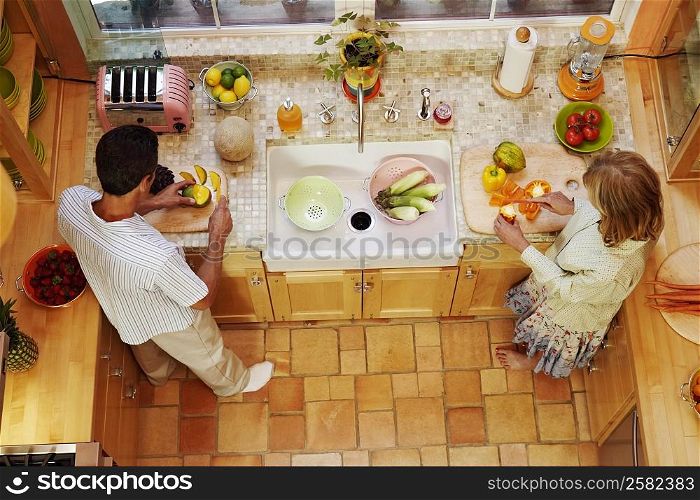 High angle view of a mature couple cutting vegetables in the kitchen