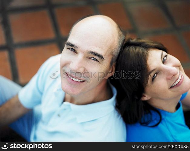 High angle view of a mature couple sitting back to back