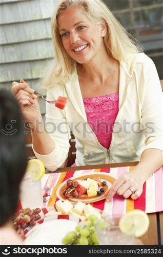 High angle view of a mature woman eating fruit salad