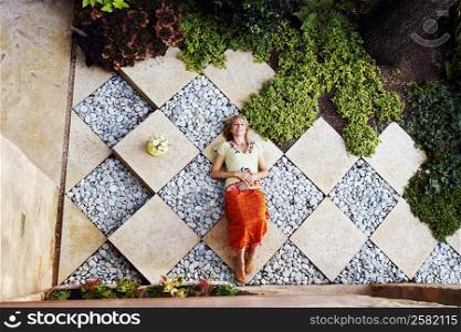 High angle view of a mature woman lying in a garden