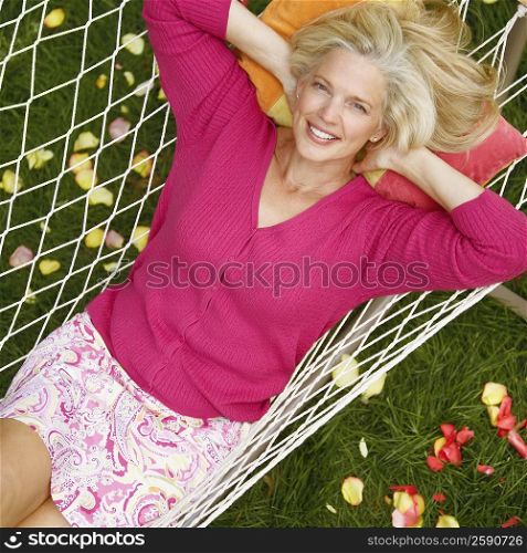 High angle view of a mature woman lying in a hammock and smiling