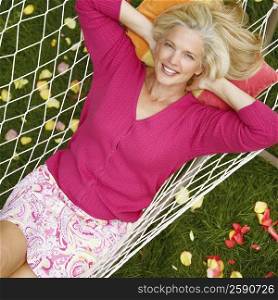 High angle view of a mature woman lying in a hammock and smiling
