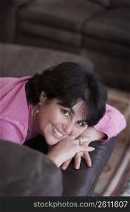 High angle view of a mature woman lying on a couch and smiling